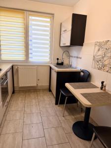 eine kleine Küche mit Tisch und Spüle in der Unterkunft Cozy Apartment 150 m from Târgu Mureș Hospital in Târgu Mureș