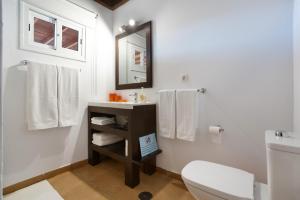 a bathroom with a sink and a toilet and towels at Almar in Tinajo +18 photos
