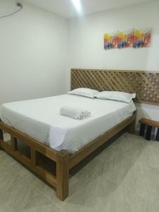 a bed with white sheets and pillows in a room at Mango Beach in San Bernardo del Viento +2 photos