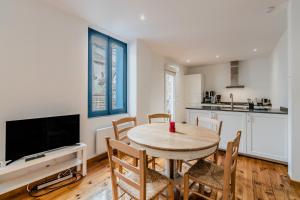 アクス・レ・テルムにあるModerne Appartement 6 personnesのテーブルと椅子のあるキッチンとダイニングルーム