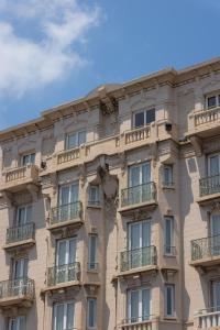 Un edificio con balcones a los lados. en Hotel Renoir, en Cannes