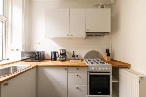 eine Küche mit weißen Schränken und einem Herd mit Backofen in der Unterkunft Amazing Apartment in Urban Neighborhood in Kopenhagen