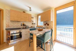 a kitchen with a table and a view of the ocean at Cesa Antermoia in Mazzin +14 photos