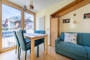 a dining room with a table and a couch at Cesa Antermoia in Mazzin