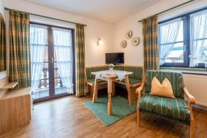 a living room with a table and a chair at Ferienwohnungen Isarwinkel in Krün