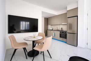 a kitchen with a table and chairs and a tv at Limassol Centr Apartament in Limassol
