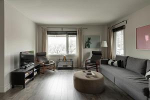 a living room with a couch and a coffee table at Downtown - Rooftop patio - Free shuttle to ski Mountain in Mont-Tremblant