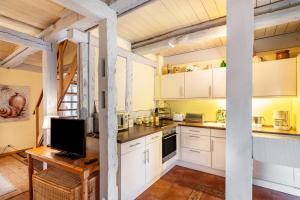 RühstädtにあるFerienhaus Altes Nachtwächterhausの白いキャビネットと木製のテーブルのあるキッチン