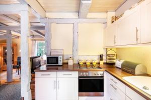 RühstädtにあるFerienhaus Altes Nachtwächterhausの白いキャビネットとコンロ付きオーブンを備えたキッチン +21枚の写真