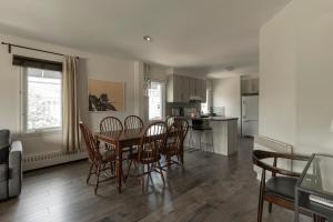 a kitchen and dining room with a table and chairs at Downtown - Rooftop patio - Free shuttle to ski Mountain in Mont-Tremblant