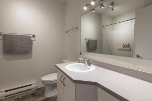 a white bathroom with a sink and a toilet at Downtown - Rooftop patio - Free shuttle to ski Mountain in Mont-Tremblant +29 photos