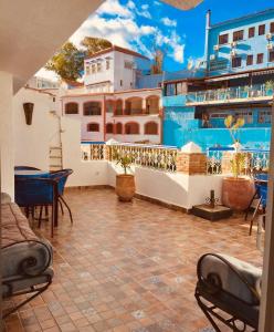 a balcony with a table and chairs and a building at Maison d'hôte Bousaid in Chefchaouene