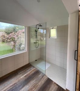 une salle de bain avec douche et fenêtre dans l'établissement Cozy Cottage, à Praia da Vitória