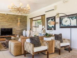 a living room with a couch and a table at 11 On Fairway Villa by Euphoric Leisure in Southbroom