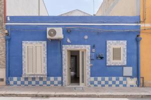 a blue building with two windows and a door at Casa Belvedere vista mare in Portopalo