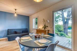 a dining room with a table and chairs and a couch at Mas Chloro-Phil in Clapiers