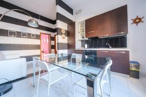 a dining room with a glass table and white chairs at Casa Via Medici in Milazzo