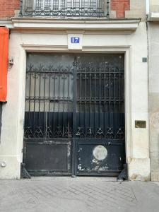 een grote zwarte deur met een bord erop bij Nation Confort & Espace in Parijs