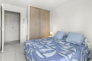 een slaapkamer met een bed met een blauw dekbed bij Un Air De Venise in Fréjus