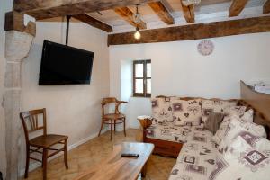 un salon avec un canapé et une télévision dans l'établissement Les hirondelles, à Saint-Maurice-de-Rotherens