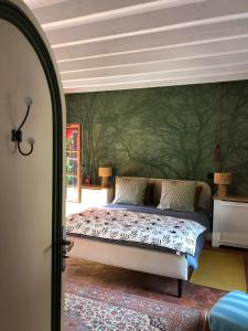a bedroom with a bed with a green wall at L'étape Impressionniste in Croissy-sur-Seine