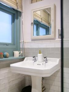 a bathroom with a white sink and a mirror at Beautiful sea front apartment with balcony in St Leonards-on-Sea in Hollington