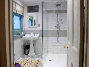 a bathroom with a sink and a glass shower at Beautiful sea front apartment with balcony in St Leonards-on-Sea in Hollington +19 photos