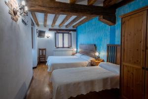 Un dormitorio con dos camas y paredes azules. en Zadorra Etxea Casa, en Salvatierra