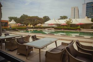 a restaurant with tables and chairs and a swimming pool at Azalaï Hôtel Nouakchott in Nouakchott