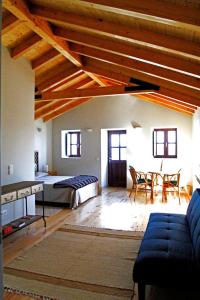 a bedroom with a bed and a table and chairs at Casa Do Cais - Torreira in Torreira