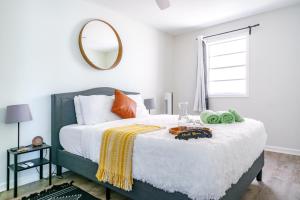 コロンバスにあるShort North - Convention - Private Parking - Pets - 2BRの壁に鏡が付いた大きなベッドのある寝室