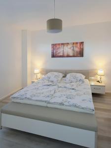 a bed in a bedroom with two night stands and two lamps at Panorama trifft Gemütlichkeit in Nümbrecht