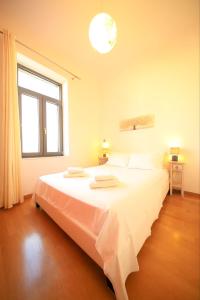 a large white bed in a room with a window at Harmony Apartment Pythagoreio Samos Center in Pythagoreio
