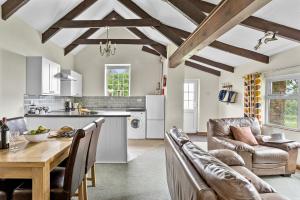 a kitchen and living room with a table and chairs at Fuchsia Cottage in Saint Endellion