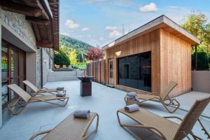 eine Terrasse mit Schaukelstühlen und einem Kamin in der Unterkunft Blu Hotel Acquaseria in Ponte di Legno + 31 Fotos