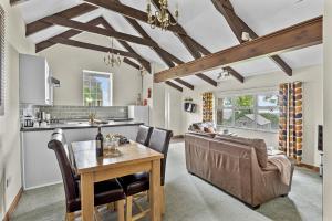 a kitchen and living room with a table and a couch at Fuchsia Cottage in Saint Endellion