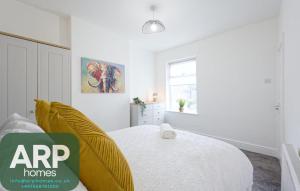 Ince-in-Makerfieldにある3 Bed House, Free Parking, Gardenのベッドと窓のある白い寝室