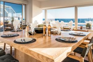 a dining room table with a view of the ocean at Villa Albatros - piscine chauffée in Saint-Mandrier-sur-Mer
