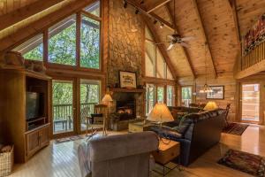 a living room with a fireplace in a log cabin at Almost Heaven in Sugar Grove