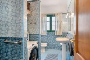 a bathroom with a toilet a sink and a washing machine at La Casa de Maika in Guatiza +20 photos