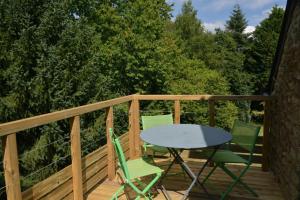 Una mesa y sillas en una terraza con árboles. en Gîte Nautilus, en Elven 11 fotos más