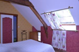 Un dormitorio con una cama blanca y una ventana. en Gîte Nautilus, en Elven