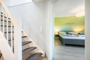 a room with a bed and a staircase with a bedroom at Haus Ankerplatz in Wischhafen