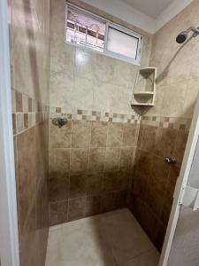 a bathroom with a shower with a glass door at Hostal Casa Macondo in Santa Marta