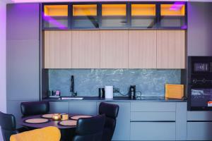 a kitchen with a table and some cabinets and chairs at Adler Apartments in Prizren
