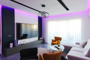a living room with a white couch and orange chairs at Adler Apartments in Prizren