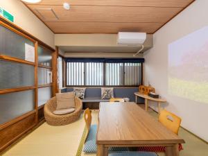 a classroom with a wooden table and chairs at kyomachiya-京町家Oneworld十条-Jujo in Kyoto
