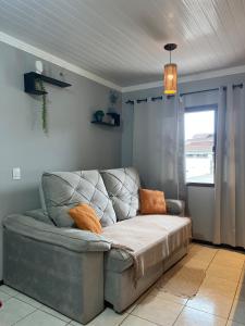 EspinheirosCasa Iririú · Casa exclusiva no terreno com jardim的客厅设有一张沙发,客厅设有窗户