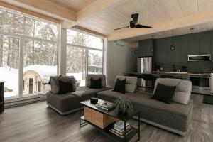 a living room with a couch and a table at Scenic Bright - Sauna - Fire - 20 min Tremblant in La Conception
