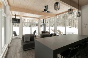 a living room with a table and chairs at Scenic Bright - Sauna - Fire - 20 min Tremblant in La Conception